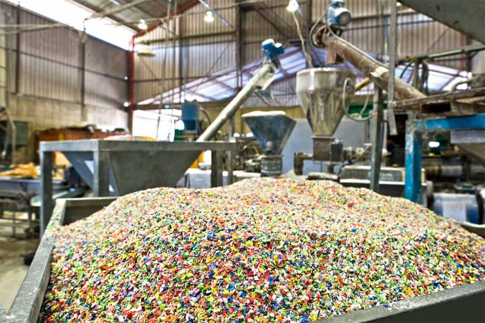 Colorful plastic regrind under a processing line
